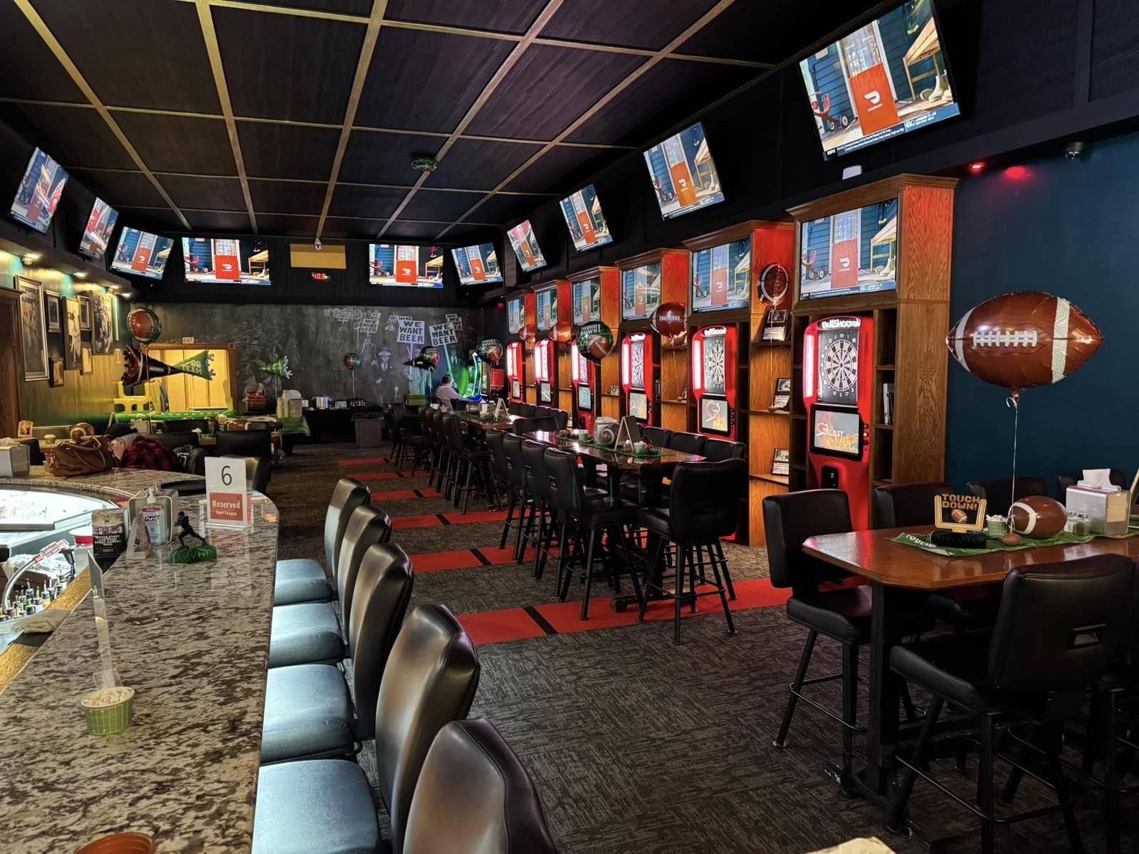 Inside The Pump 2.0: the long granite bar, a wall of dart machines and TVs everywhere